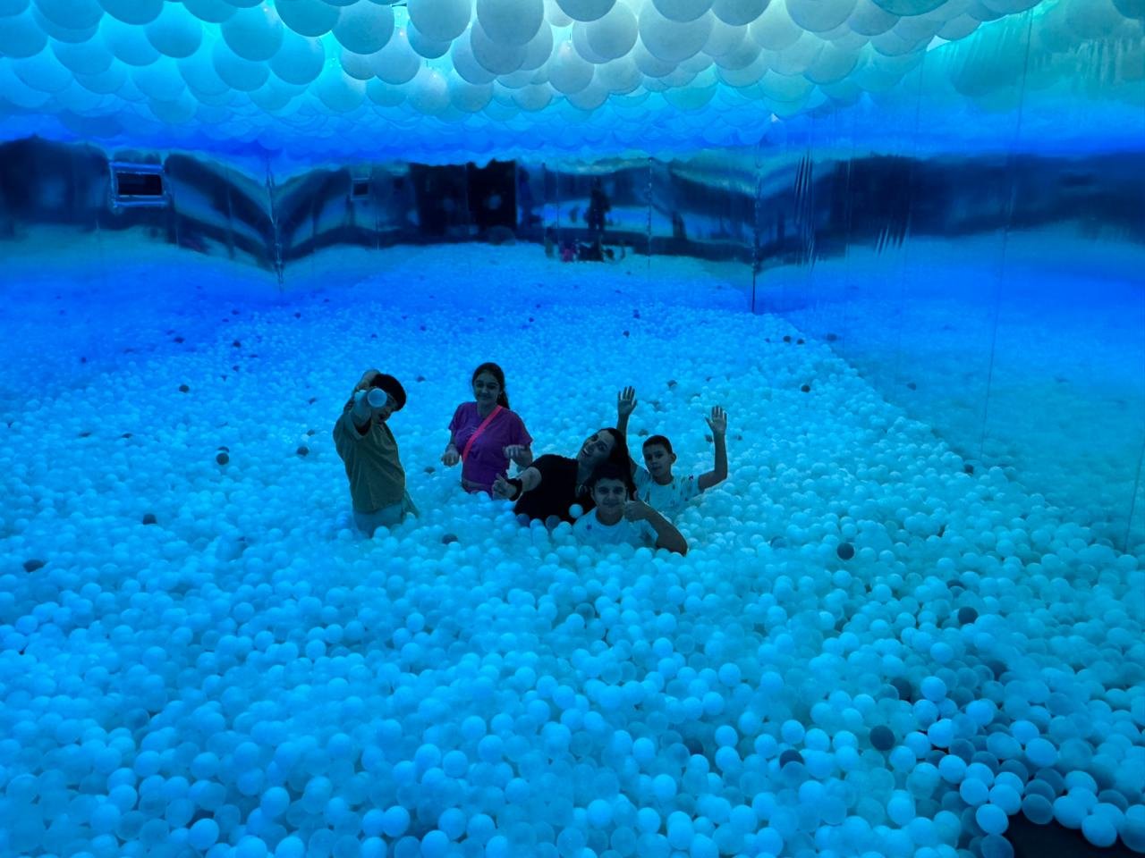 Grupo em uma experiência recreativa em piscina de bolinhas